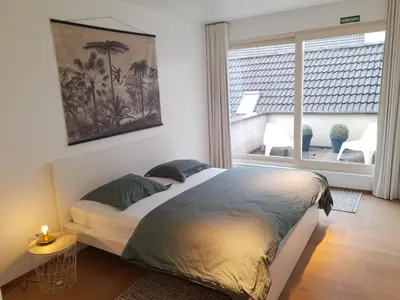 a bedroom with a large bed with a window at Vakantiewoning 'De Vlaamse Aap' in Dilsen-Stokkem