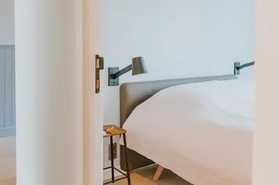 a bedroom with a bed and a side table at Kipdorp39 in Bree