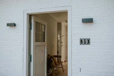 a door with a clock on the side of a building at Kipdorp39 in Bree