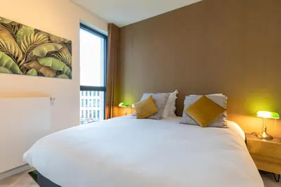 a bedroom with a large white bed with two pillows at GUILLEMINS STATION FLATS in Liège