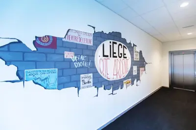 a wall mural in a room with a brick wall at GUILLEMINS STATION FLATS in Liège