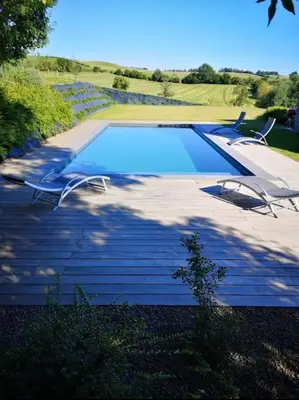 a swimming pool with two lawn chairs next to it at Ô'bel Écrin in Aubel