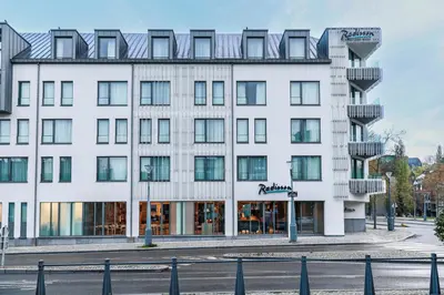 a large white building with windows at Radisson Hotel Liege City Centre in Liège