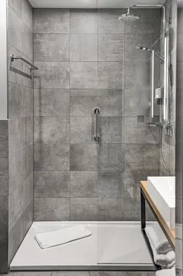 a shower with a glass door next to a sink at Radisson Hotel Liege City Centre in Liège