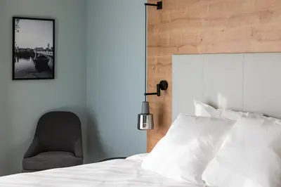 a bedroom with a white bed and a chair at Radisson Hotel Liege City Centre in Liège