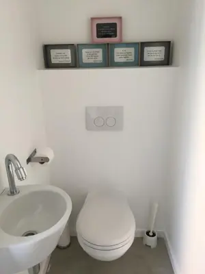 a bathroom with a white toilet and a sink at Le temps d’une balade. in Olne
