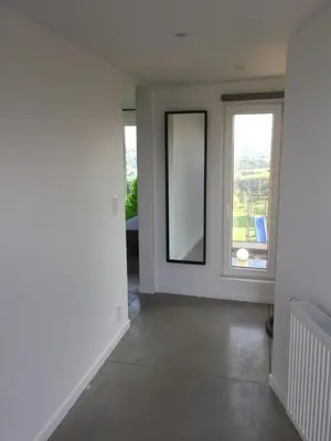 an empty room with a mirror and a window at Le temps d’une balade. in Olne