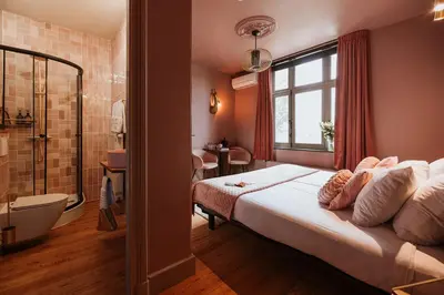 a bedroom with a large bed and a bathroom at B&B het Notarishuis - authentiek verblijf nabij Maastricht in Voeren