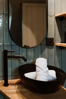 a black sink with towels in a bathroom at B&B het Notarishuis - authentiek verblijf nabij Maastricht in Voeren