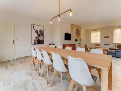 a large dining room with a large wooden table and white chairs at Heers Retreat with Sauna in Heers
