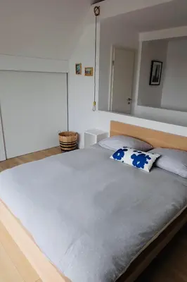 a bedroom with a large bed with two pillows on it at Ons Maashuisje in Maaseik