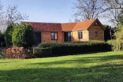 a house with a green yard in front of it at Chalet Duras in Sint-Truiden