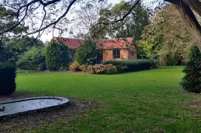 a house in a yard with a green lawn at Chalet Duras in Sint-Truiden