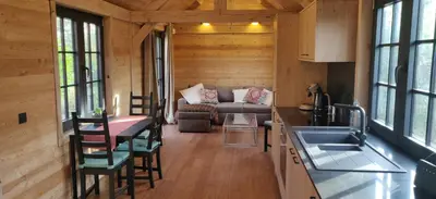 a kitchen and living room in a log cabin at Chalet Duras in Sint-Truiden