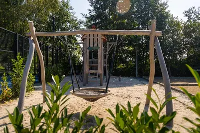 a playground with a swing in the sand at Glamping - 25 min Roermond, Maasmechelen & Maastricht in Kinrooi