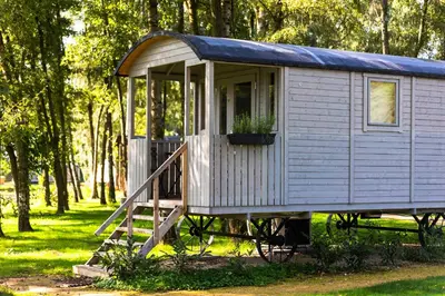 a tiny house with a porch and a window at Glamping - 25 min Roermond, Maasmechelen & Maastricht in Kinrooi