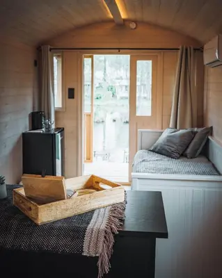 a room with a bed and a table and a window at Glamping - 25 min Roermond, Maasmechelen & Maastricht in Kinrooi