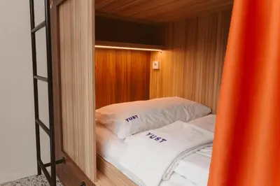 a room with a bed with white sheets and pillows at YUST Liege in Liège