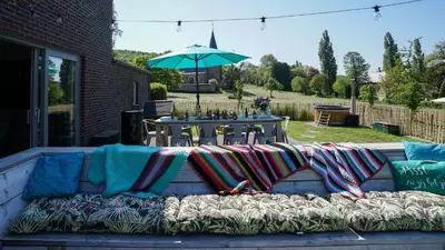 a couch with blankets on it sitting on a patio at SINTPIETER18 @Lo-Ghis vakantiewoning in Voeren
