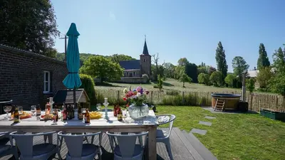a table in a yard with an umbrella at SINTPIETER18 @Lo-Ghis vakantiewoning in Voeren