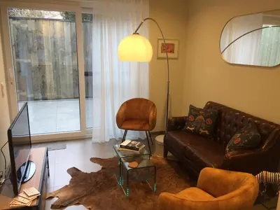 a living room with a couch and a chair at Gezellig stadshuisje met patio. in Tongeren