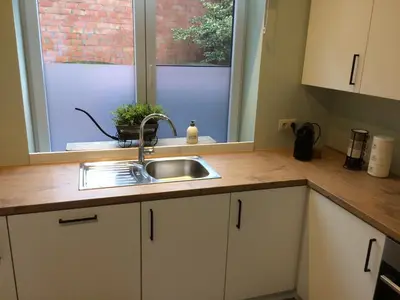a kitchen counter with a sink and a window at Gezellig stadshuisje met patio. in Tongeren