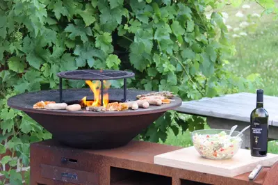 a fire pit on a table with a bottle of wine at Hoeve Luitenant Halleux in Linter