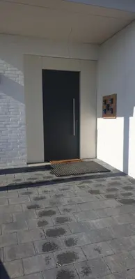 a black door in a white room with a brick wall at Louis in Maaseik