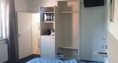 a bedroom with a door open to a refrigerator at Louis in Maaseik