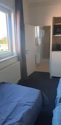 a bedroom with a blue bed and a window at Louis in Maaseik