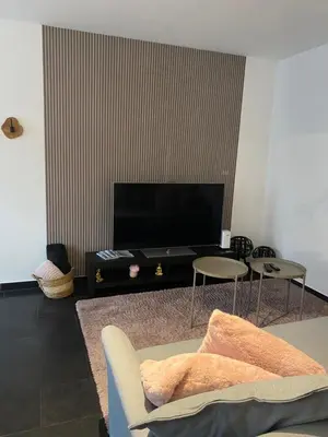 a living room with a couch and a flat screen tv at La suite de lati in Liège