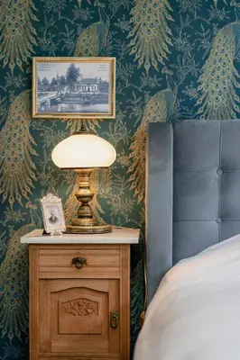a lamp on a night stand next to a bed at Villa les Bruyères in Dilsen-Stokkem