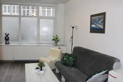 a living room with a couch and a window at Elena's Apartment in Liège