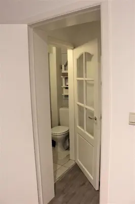 a bathroom with a toilet and a white door at Elena's Apartment in Liège