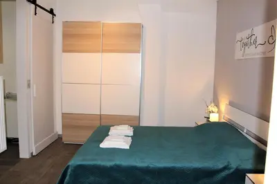 a bedroom with a green bed with towels on it at Elena's Apartment in Liège