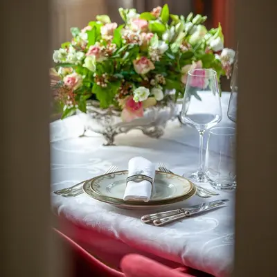 a table with a plate and a vase of flowers at Villa Asch in As