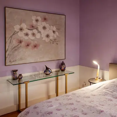 a bedroom with a glass table and a painting on the wall at Villa Asch in As