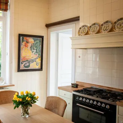 a kitchen with a table with a vase of flowers at Villa Asch in As