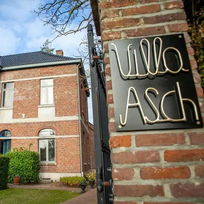 a sign on the side of a brick building at Villa Asch in As