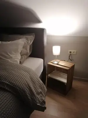 a bedroom with a bed and a table with a lamp at Het Innerhof in Oudsbergen