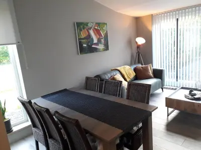 a living room with a table and a couch at Het Innerhof in Oudsbergen