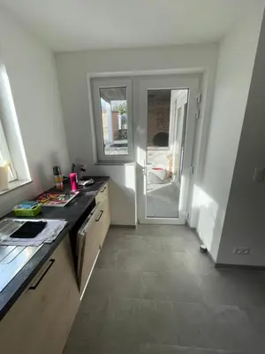 a kitchen with a door leading to a patio at Appartement avec extérieur à proximité de Liège in Herstal