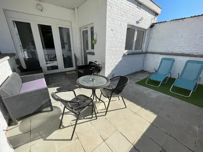a patio with a table and chairs and a couch at Appartement avec extérieur à proximité de Liège in Herstal