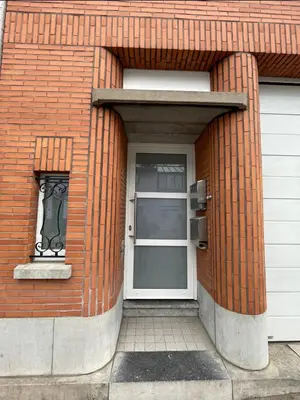 a brick building with a door and a window at Appartement avec extérieur à proximité de Liège in Herstal