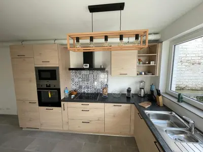 a kitchen with wooden cabinets and a sink at Appartement avec extérieur à proximité de Liège in Herstal