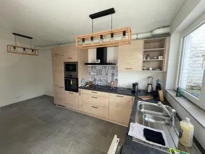 a kitchen with wooden cabinets and a sink at Appartement avec extérieur à proximité de Liège in Herstal
