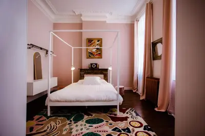 a bedroom with a canopy bed in a pink room at GITADIN - Deluxe Suite Valens - Historical Center in Liège