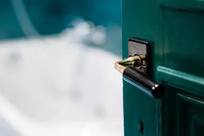 a green door with a metal door knob at GITADIN - Deluxe Suite Valens - Historical Center in Liège