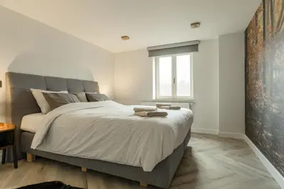 a bedroom with a large bed and a window at De Dommelhoeve in Peer