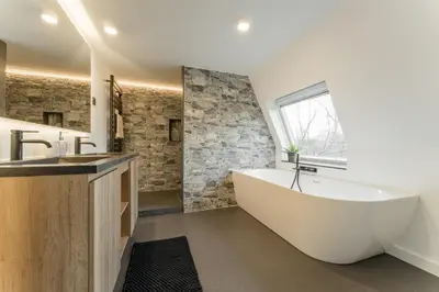 a bathroom with a large white tub and a window at De Dommelhoeve in Peer